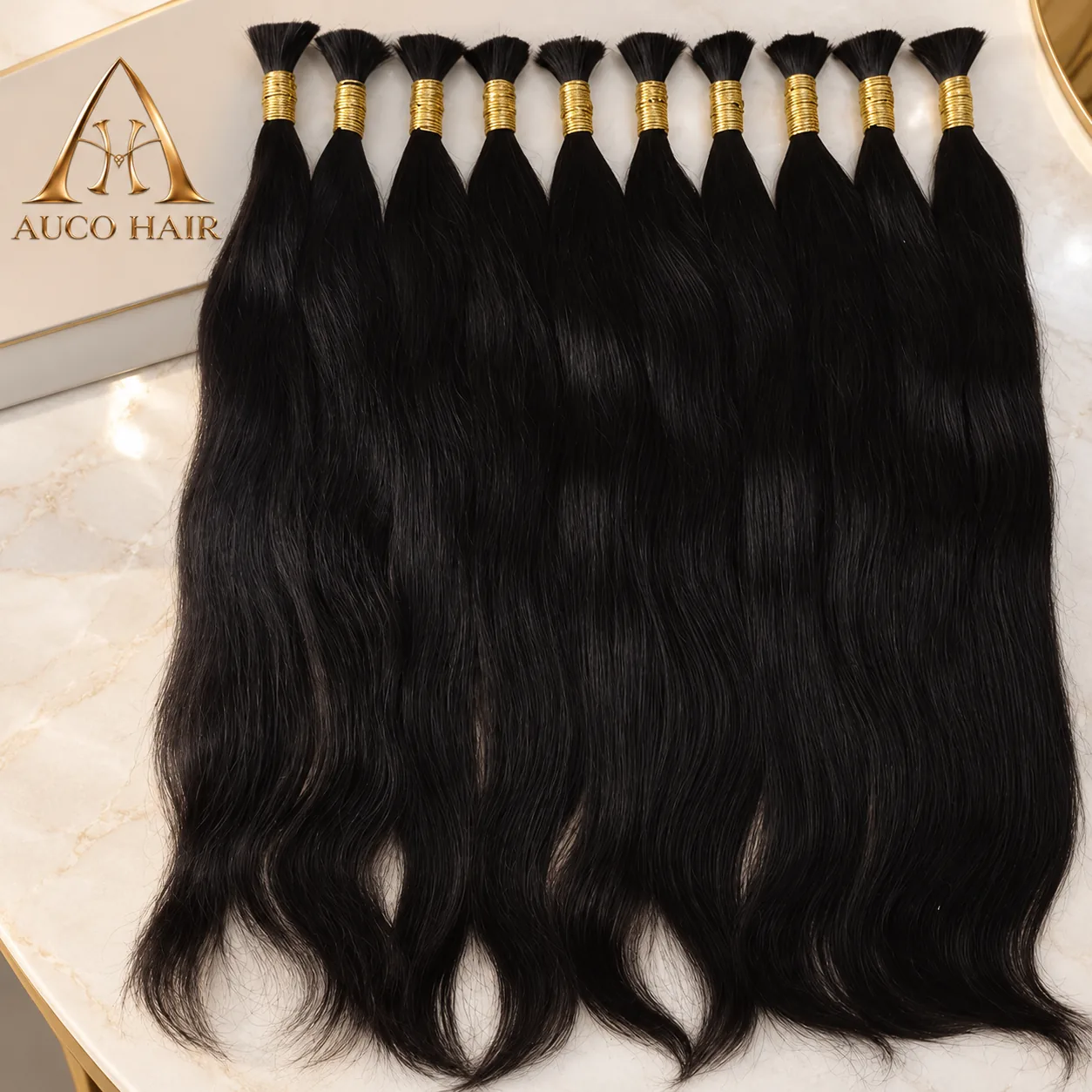 AUCO HAIR natural black Vietnamese bulk hair bundles with gold bands on an ivory stone table