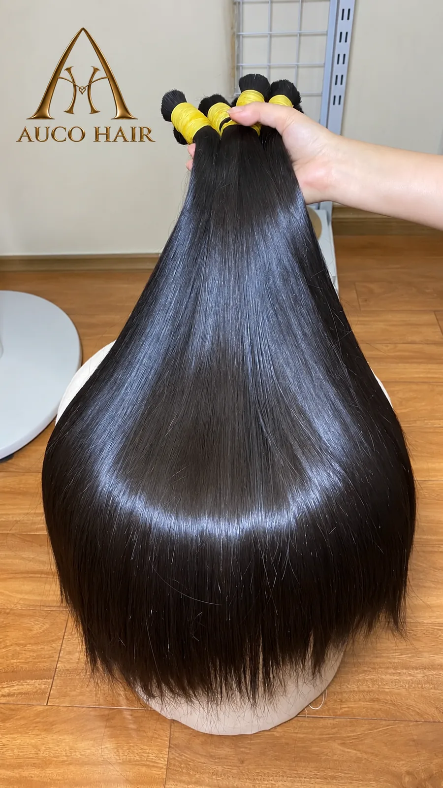 Long straight raw Vietnamese hair held up to show the length and natural shine